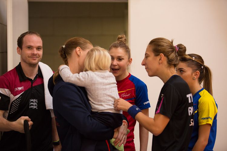 Große Attraktion gleich nebenan: Dana Cechova schaut mit ihrem Kind vorbei und bringt Daniela Dodean-Monteiro, Elizabeta Samara und Bernadette Szöcs zur Verzückung. Und was denkt Paul Drinkhall? (©Fabig)