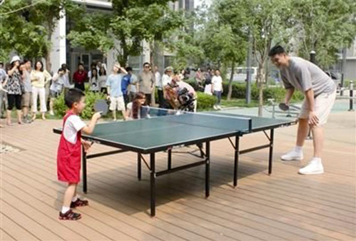 Yao Ming kommt aus dem Land des Tischtennis, da macht es doch nichts, dass er eigentlich Basketball spielt und ihm der Tisch bis zum Knie reicht (©Uberpong)
