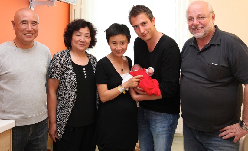 'Susis' Eltern kamen extra zur Geburt ihres Enkelkindes aus Peking nach Linz - und hätten Annas ersten Geburtstag fast verpasst. Ihre Tochter war im Alter von 15 Jahren nach Österreich gegangen, ohne ein Wort Englisch oder Deutsch zu sprechen. Auch Froschberg-Manager Renner gratulierte. (©Konventhospital Barmherzige Brüder Linz) 
