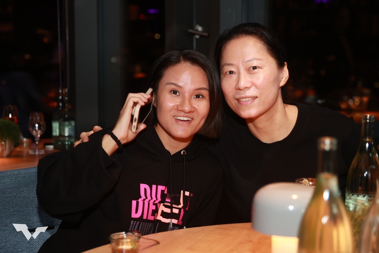 Xiaoxin Yang mit einem Ohr am Telefon, mit einem Ohr bei Fu Yu (©ITTF)