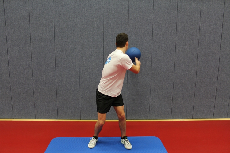 Übung 5 (Medizinballwurf gegen Wand "rückwärts"): Werfen Sie den Ball aus einer Rumpfdrehung gegen die Wand. (©Schäbitz)